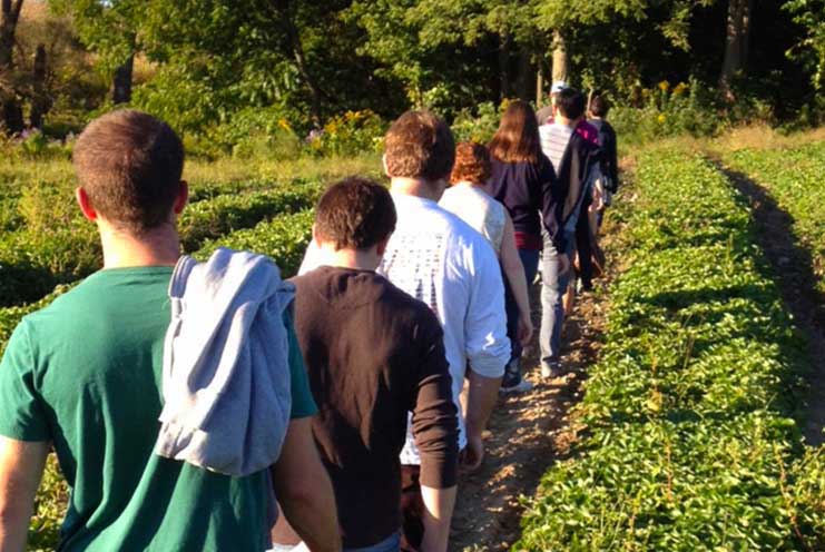 Students walk in a farmer's field