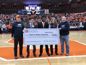 SPM Club members and beneficiaries posed in Dome with a large check