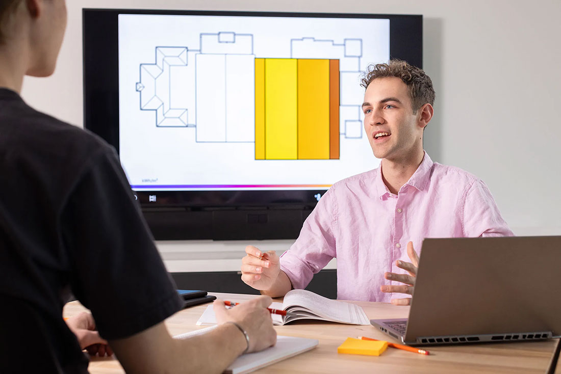 Student sitting across table from another student having a conversation