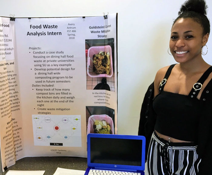 Avery Antrum stands next to her research poster