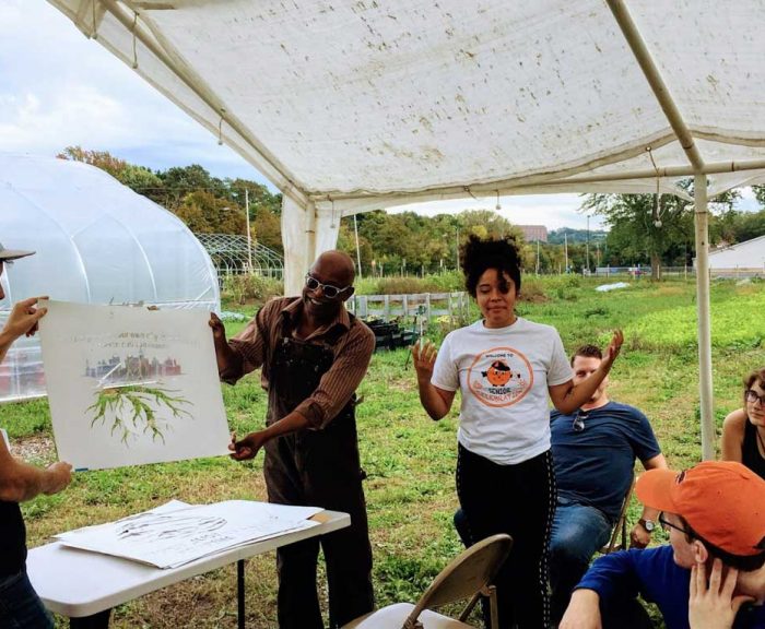 Student talk with attendees in outdoor tent