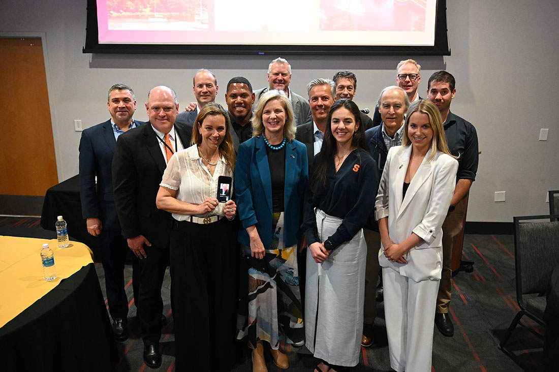 Falk faculty members standing together who attended SEIcon's "Business in Sport" conference