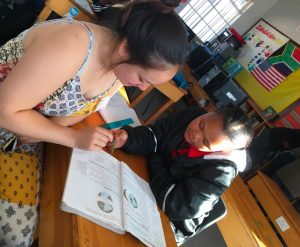 Caitlin Mogan with a student in a school classroom in South Africa 