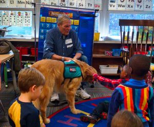 Man with dog in an elementary school classroom