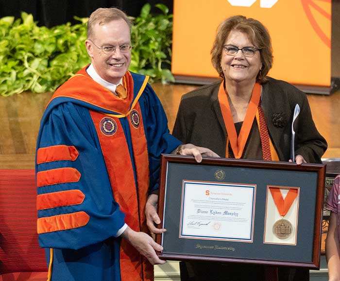 Diane Murphy posses with Chancellor Syverud with an award between them
