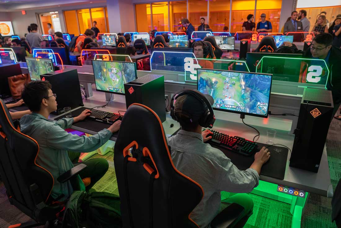 Students are sitting at esports computer consoles in a room