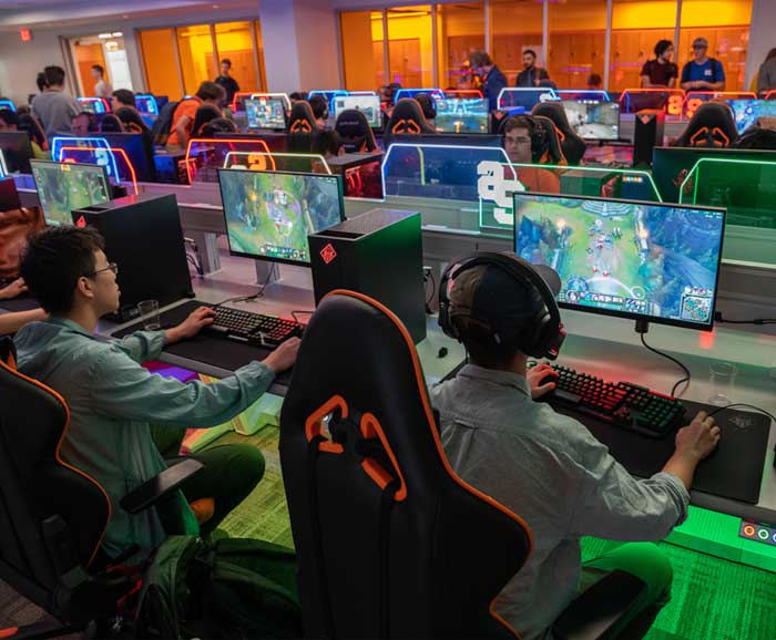Students are sitting at esports computer consoles in a room