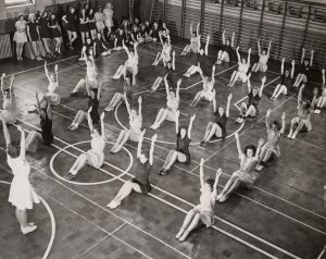 A 1940s photo of a gym full of women working out.