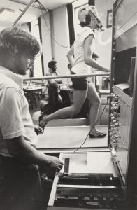 A 1977 photo of a researcher with a machine hooked up to a running student.