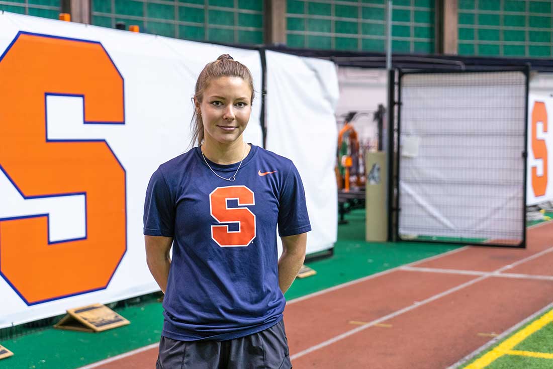 Caleigh stands in an indoor field