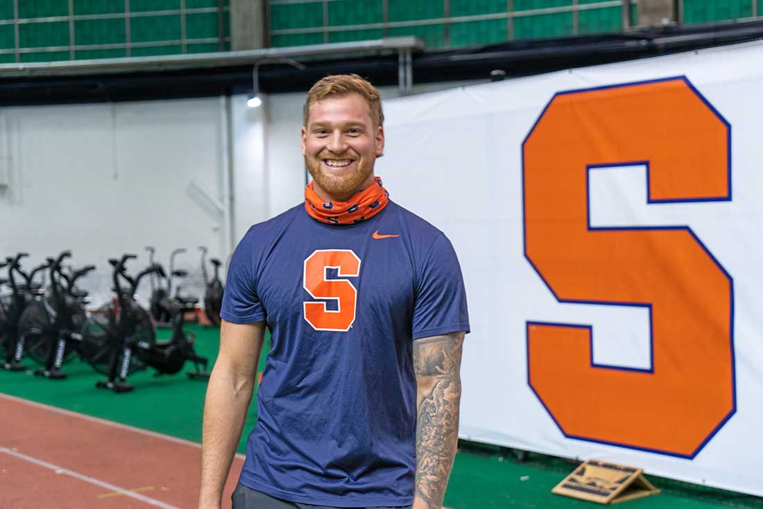 Lucas stands in an indoor field