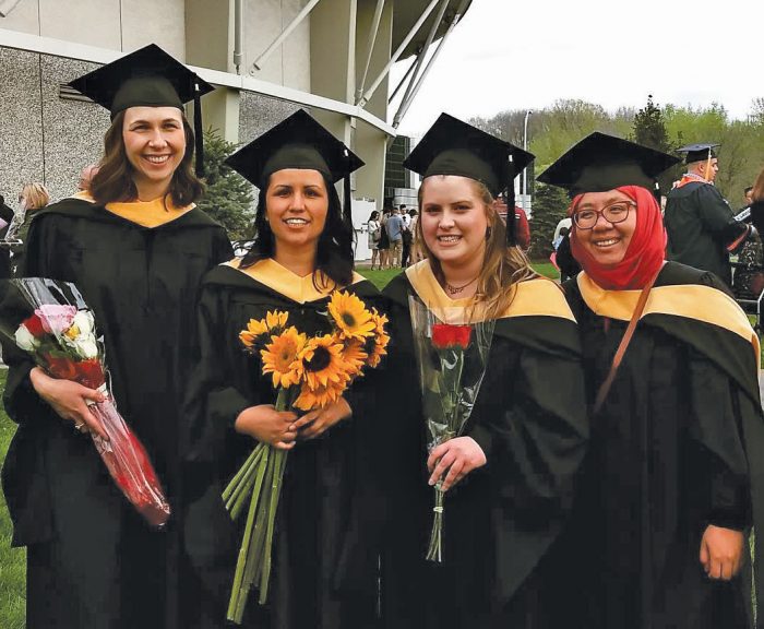 Graduates pose outside Manley Field House