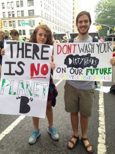 2 students hold signs saying "There is no planet B" and "don't wash your dirty hands on our future"
