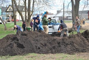 10 persons are working on a park moving soil