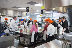 Students watch a presentation in a commercial teaching kitchen