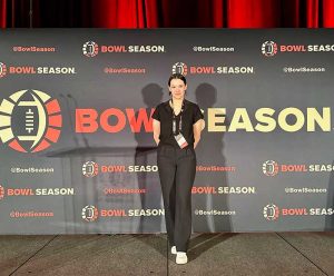 Faith Porter stands in front of a Bowl Season banner