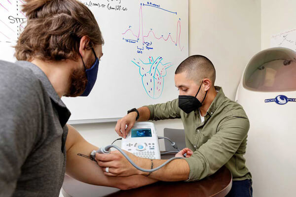 Justin Pascual monitors another person in a lab.