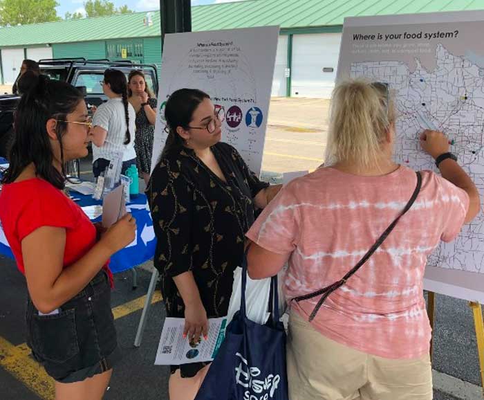 Three persons look at a poster together