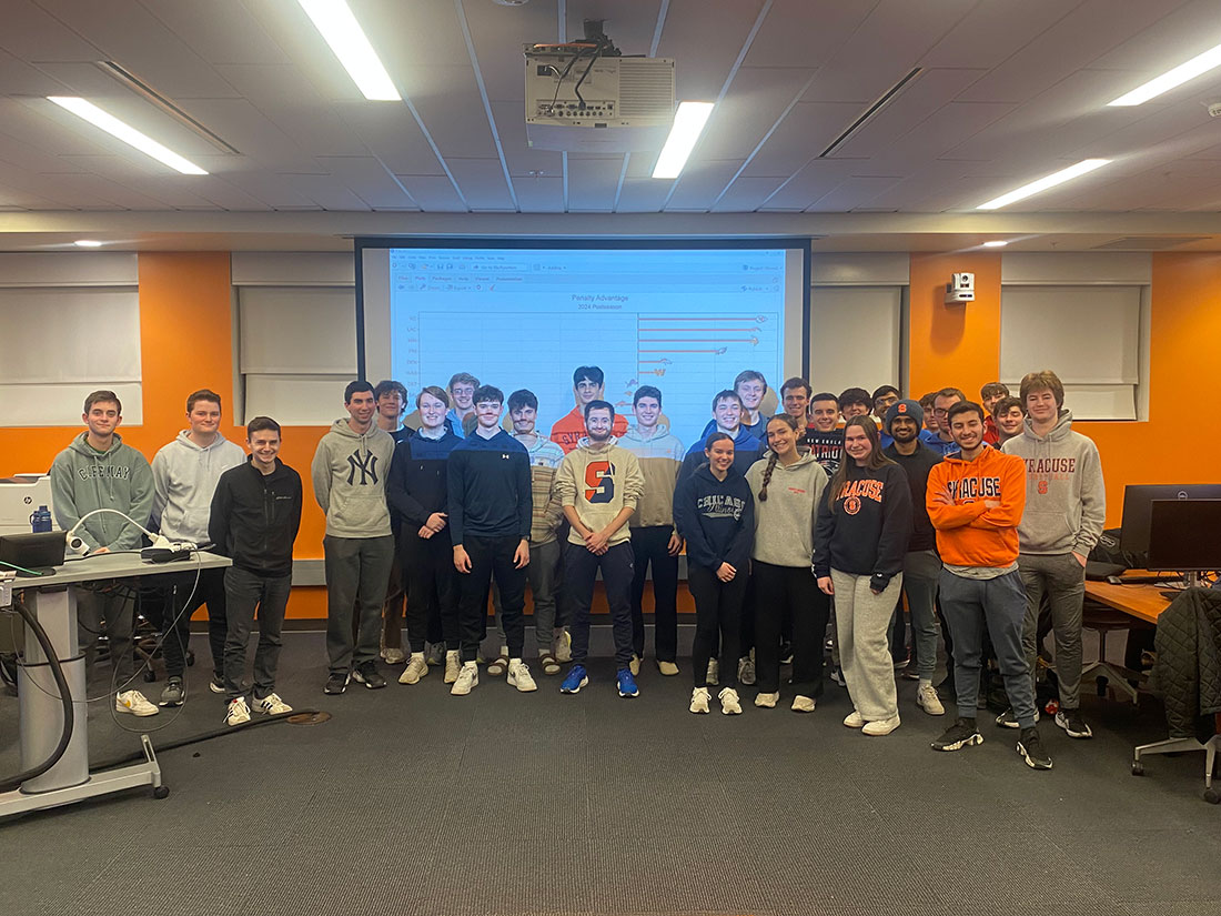 SAL Football analytics members standing together in front of a classroom 