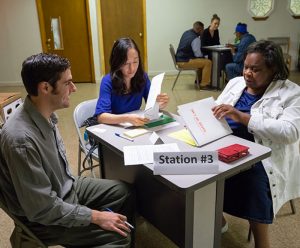 Students work with a client at a table