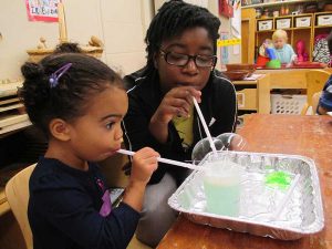 HDFS student does a science experiment with a young girl