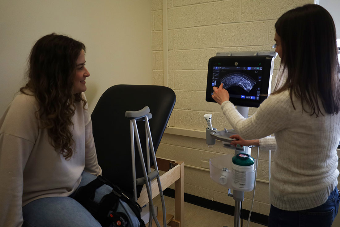 Teacher onitoring muscle strength on student