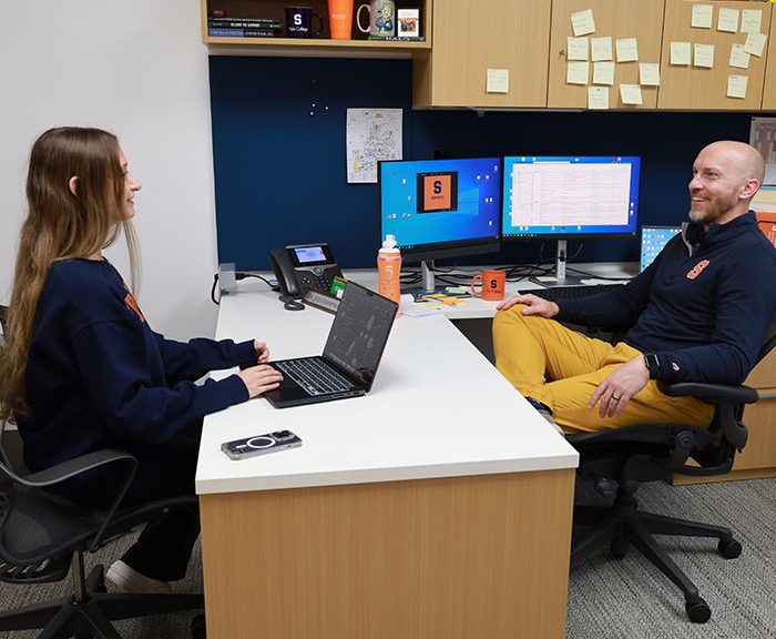 female student sitting across the desk from male professor