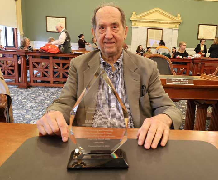 Jim Stone with and award in a courtroom