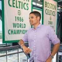 Justin Brown stand in front of a Boston Celtics sign