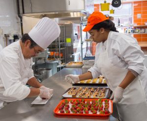 Chef Instructor Uyehara and a Falk student prepare food in Falk College's Klenk Kitchens.