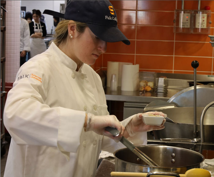 female student preparing food in Klenk kitchen Syracuse University