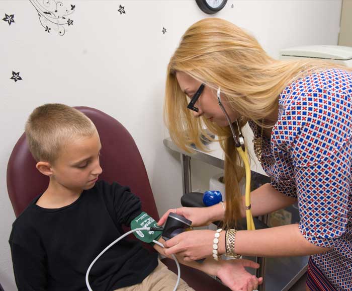 A graduate student measures the blood pressure of a child