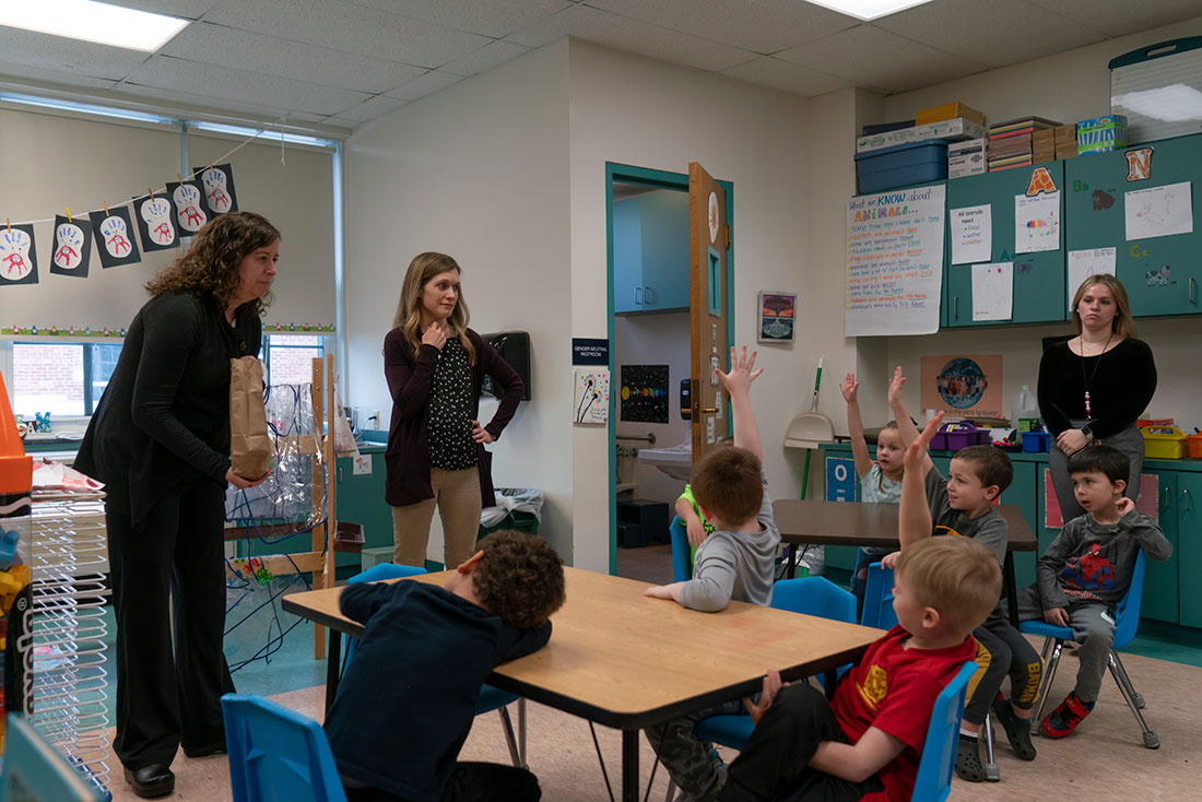 Three female teachers in a classroom with 6 pre-k students