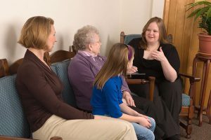 A student counsels a family of a mother daughter and grandmother