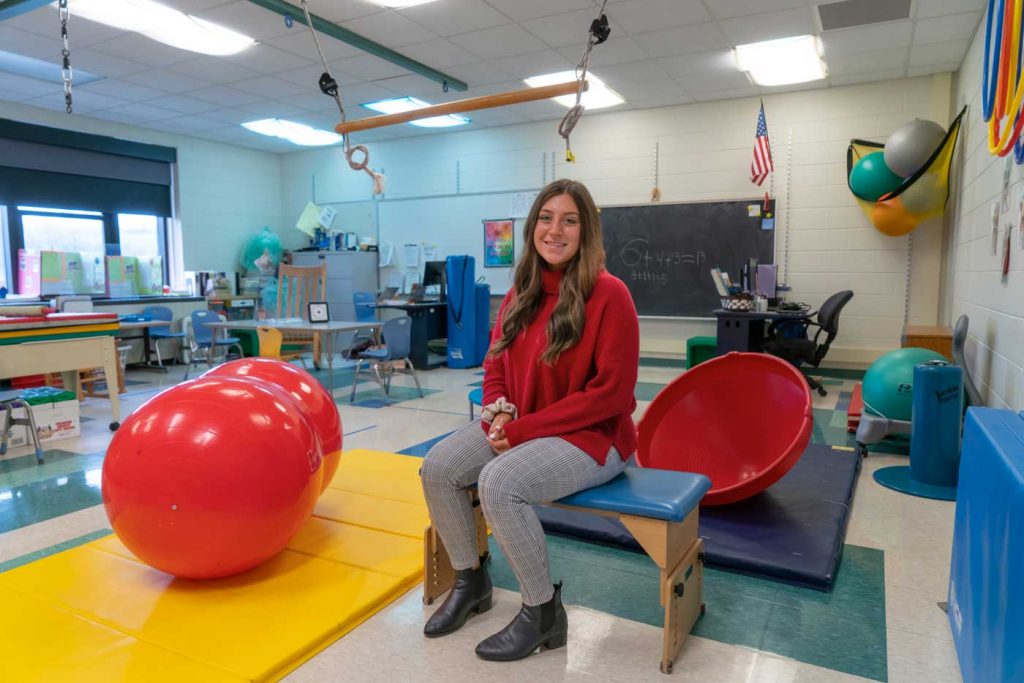 Madalyn Tallo in a room full of workout equipment for children