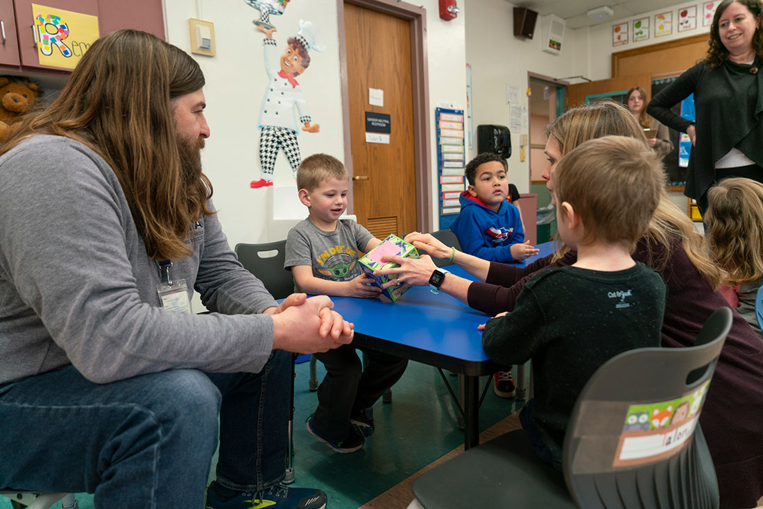 Teachers and pre-k students sitting around a table