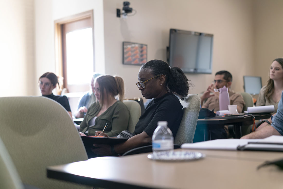 A group of students are sitting together at tables in a class.