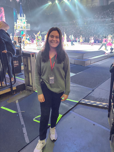 Molly posed in a stadium with a performance behind her