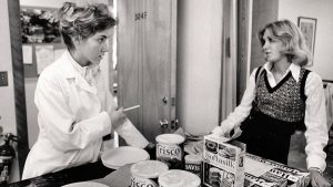 2 women are discussing over a kitchen counter