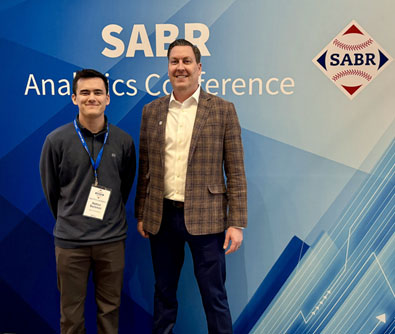 Student with award for best presentation standing with faculty member at conference