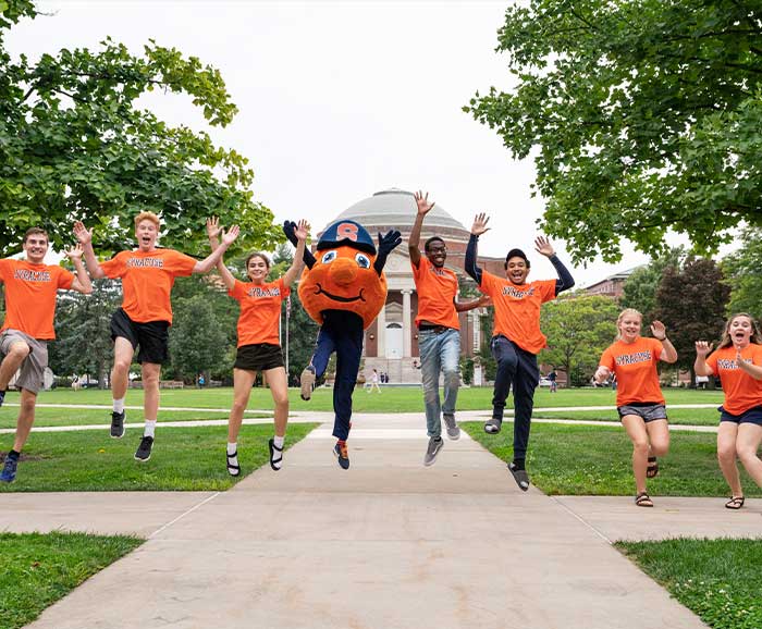 Students jumping into the air with Otto