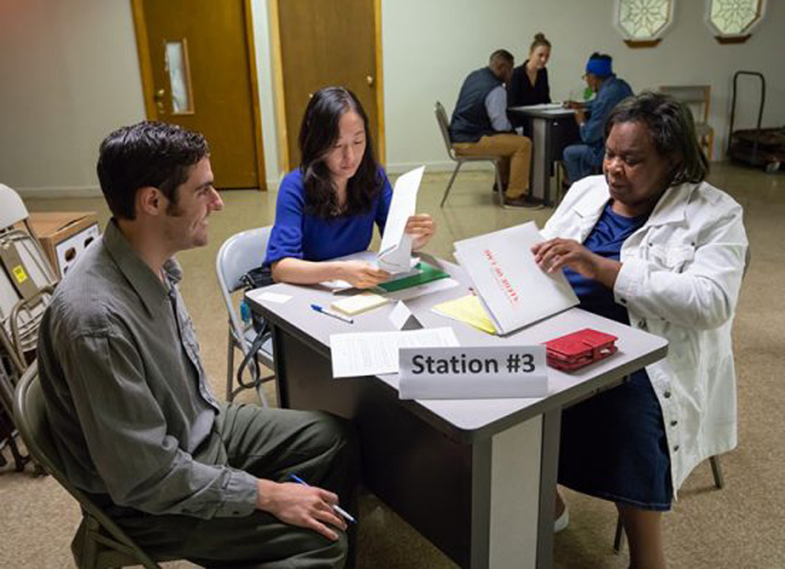 Three sit at a consultation table.