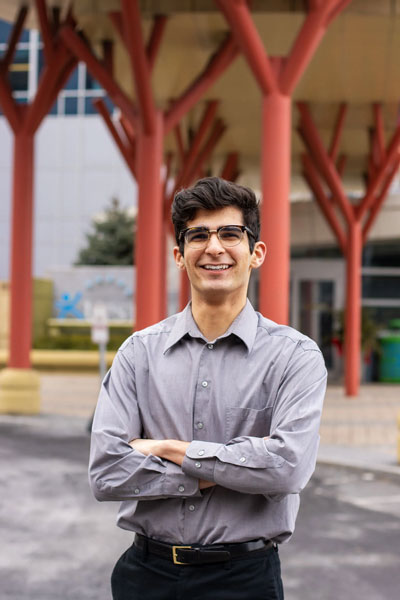 Nathan Torabi  poses outside with an unknown building in the background.