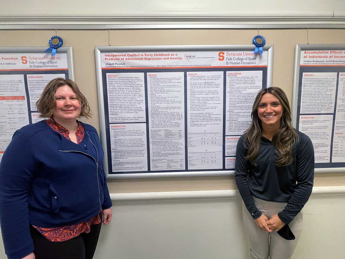 Two students stand in front of a research poster