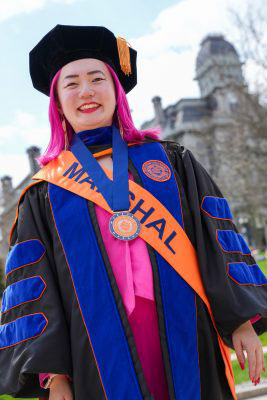Qingyang Liu in cap and gown outside the Hall of Languages