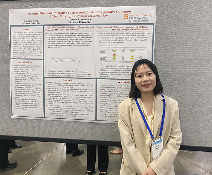 Qingyang Liu stands beside her conference poster