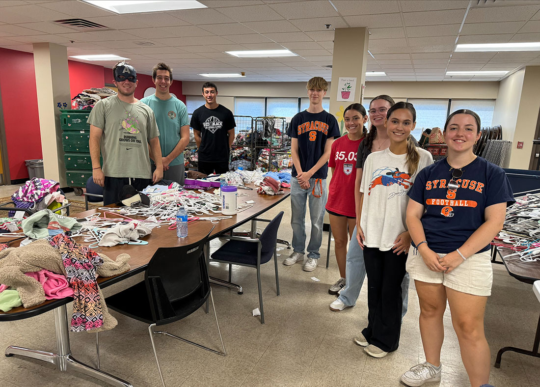 Sport management club members standing around tables as they volunteer at the Rescue Mission