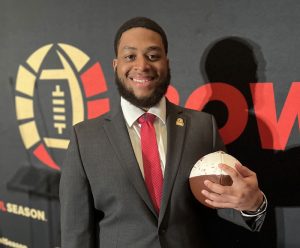 Ryan Charles poses with an American football