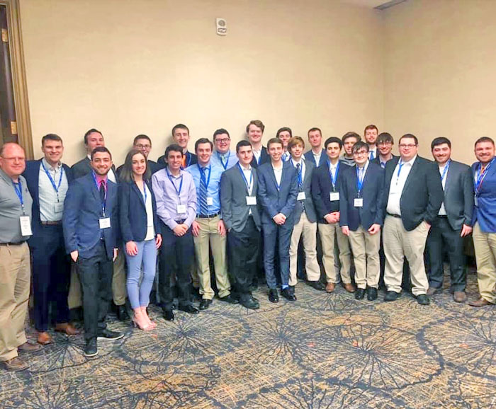 23 SPM students and faculty pose in conference room