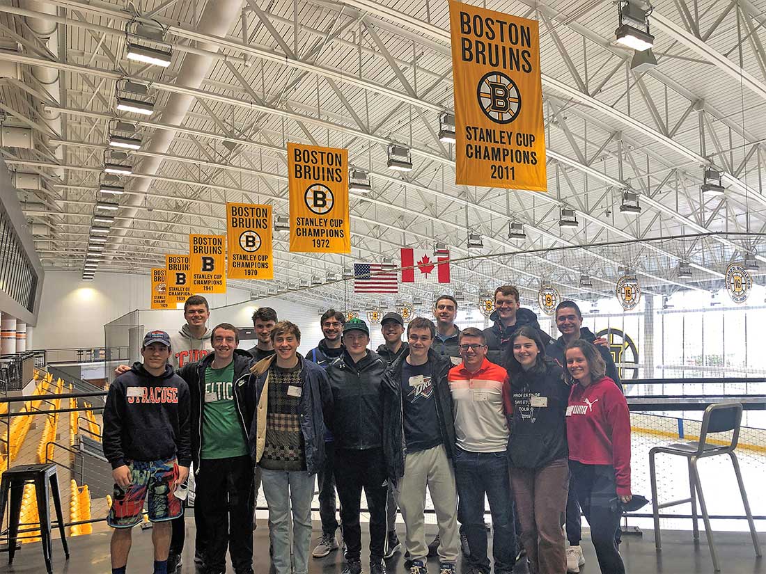 A group are posed in the Boston Bruins practice stadium 